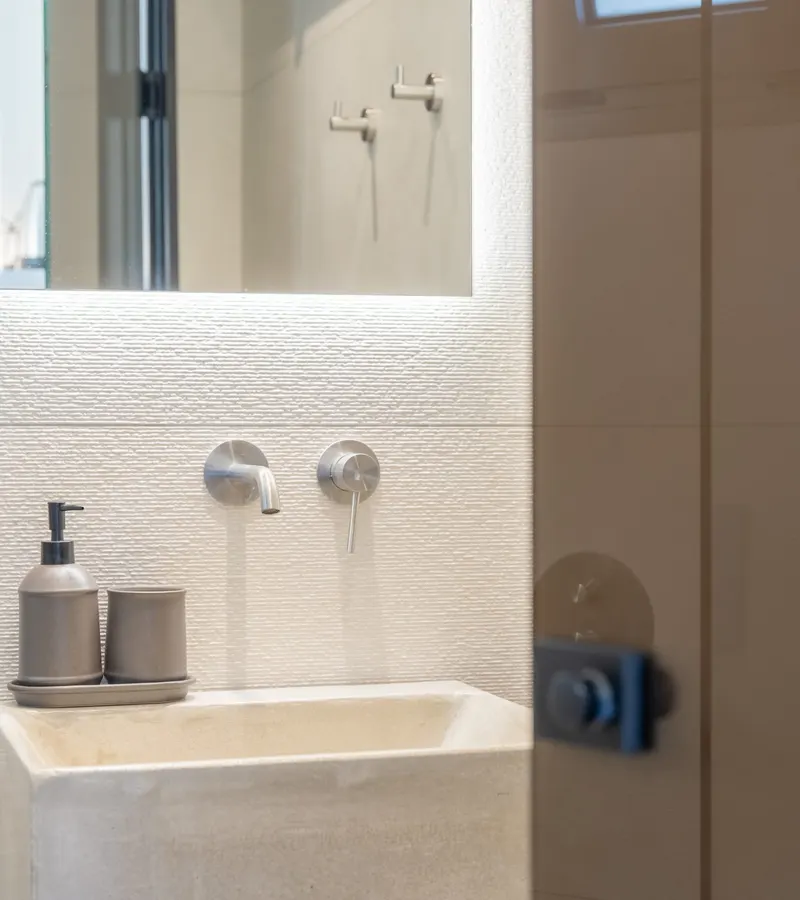 Badezimmer mit Steinwaschbecken und warmem Licht
