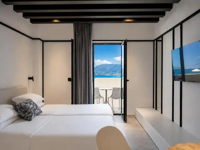 Studio bedroom with TV and open balcony to the sea