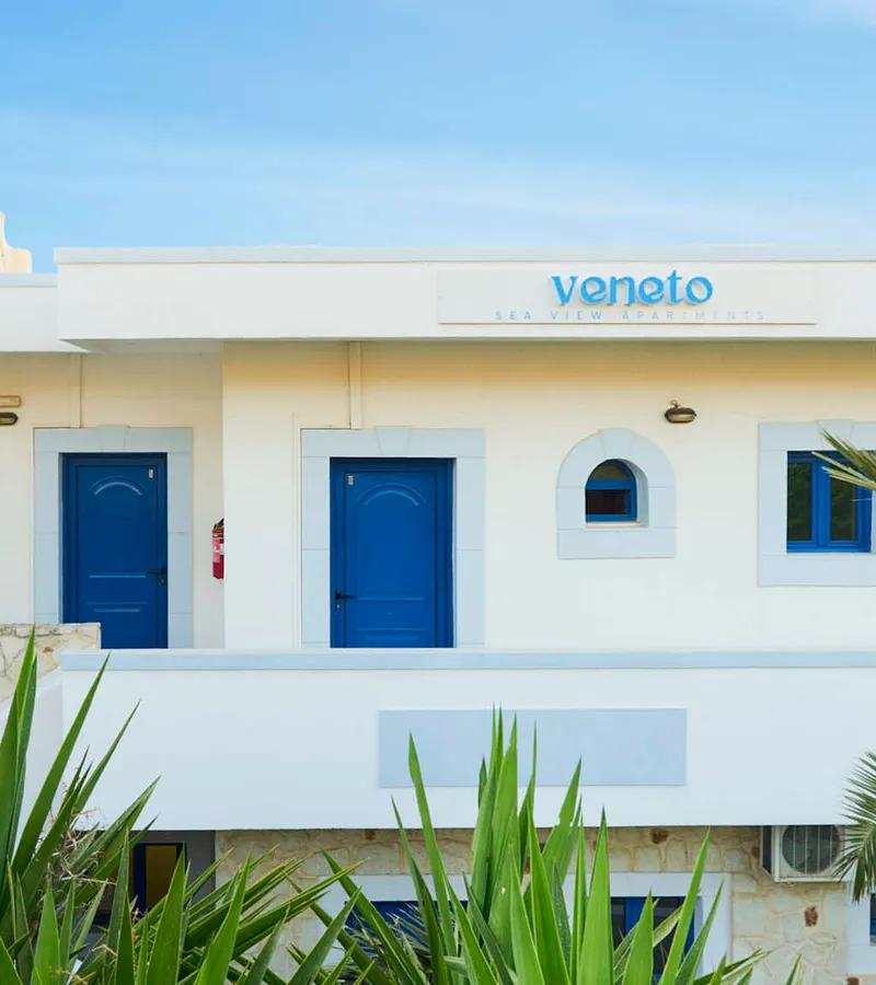 Weiße Fassade und Garten der Veneto Sea View Apartments in Stalis